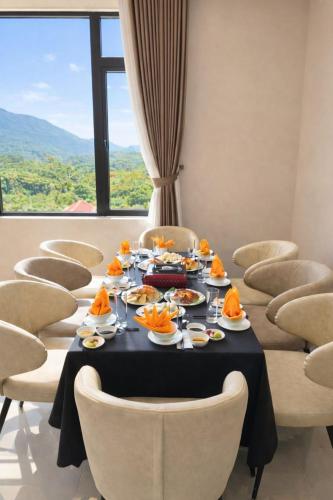 a dining room with a table with food and chairs at HAO LAN LUXURY Hotel in Bắc Quang