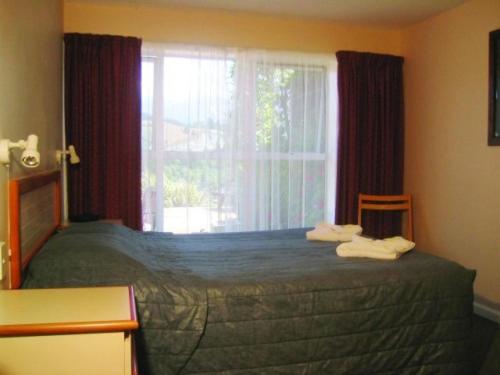 Schlafzimmer mit einem großen Bett und einem Fenster in der Unterkunft Mt Hutt Lodge in Windwhistle