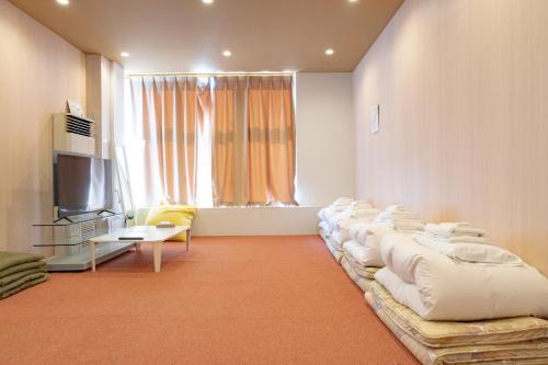 a living room with a row of pillows on a couch at KIBOTCHA/キボッチャ in Higashimatsushima