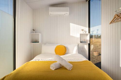 ein Schlafzimmer mit einem Bett, auf dem zwei Handtücher liegen in der Unterkunft Billy Button by Tiny Away in Maindample