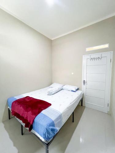 a white bedroom with a bed and a white door at SYARIAH - 3BR Homeyy by Sakura in Krawang