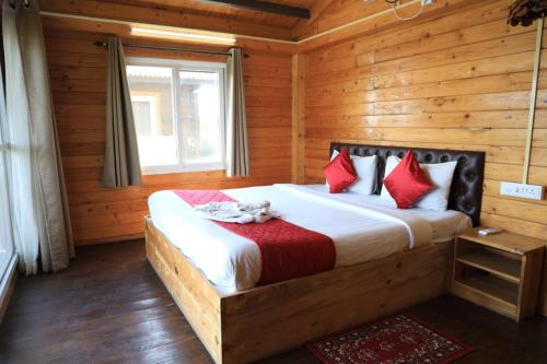a bedroom with a bed in a log cabin at Therpup Resort in Bangalore
