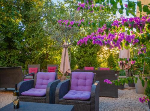 a group of chairs with purple cushions and purple flowers at Pula Garden Apartments with Shared Pool in Pula