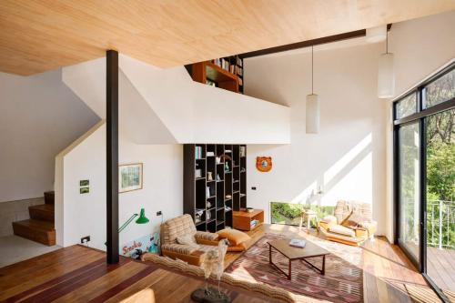 a large living room with white walls and a large window at Blackpool House - Stay Waiheke in Oneroa