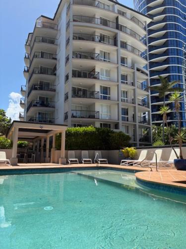 a swimming pool in front of a large apartment building at San Mateo On Broadbeach in Gold Coast