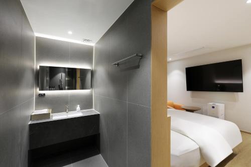 a bedroom with a bed and a sink and a tv at 부천 브라운도트 호텔 부천역점 in Sosa