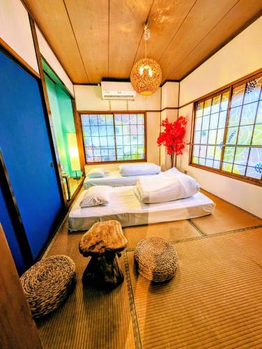 a bedroom with a large bed in a room with windows at Kaido Yuzawa Onsen Hostel in Yuzawa