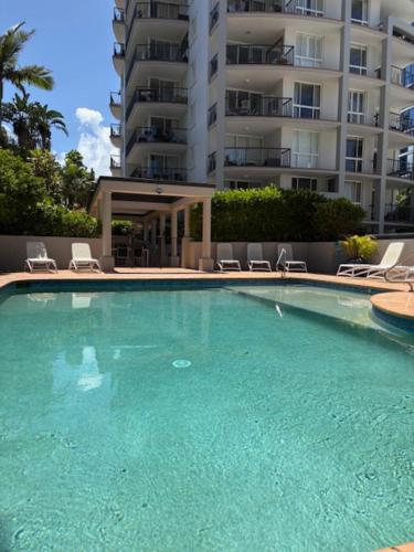 a large swimming pool with chairs and a building at San Mateo On Broadbeach in Gold Coast
