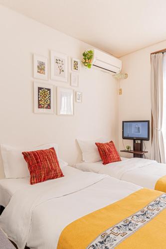 two white beds in a room with a tv at Happy House NIshi-Koiwa Keisei Koiwa Station 5min in Tokyo