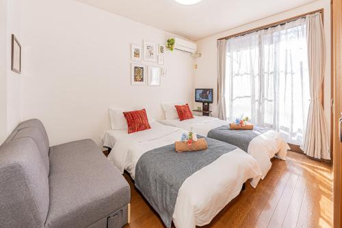 a living room with three beds and a couch at Happy House NIshi-Koiwa Keisei Koiwa Station 5min in Tokyo