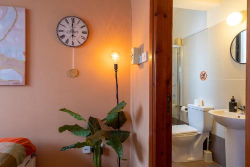 a bathroom with a clock on the wall and a plant at Johny's Spot in Larnaca in Larnaca