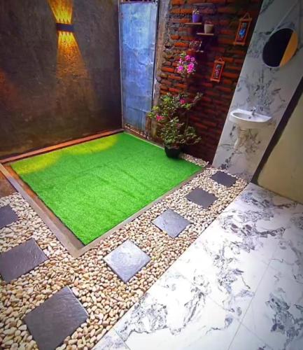 a room with a green lawn on the floor at Villa Kanaya in Sukapura