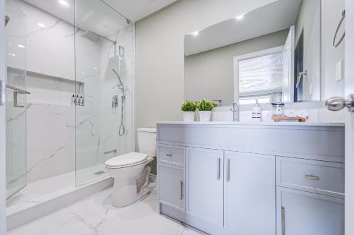 a bathroom with a shower and a toilet and a sink at Cozy Studio with 2 Beds & Private Bathroom in Toronto