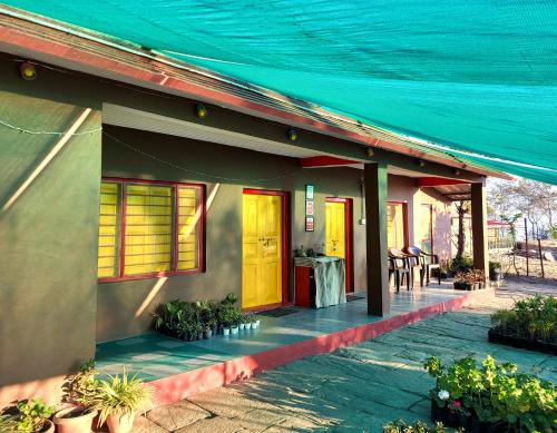 a house with yellow doors and a table with chairs at Traveller Hive Kasar Devi in Almora