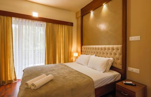 a bedroom with a large bed with two towels on it at River Whisper Villa in Cochin