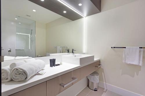 a white bathroom with two sinks and a mirror at Alexandra Hills Hotel in Cleveland