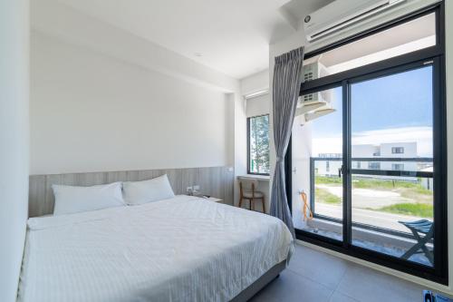 a bedroom with a bed and a large window at IsShoNi B&B in Huxi