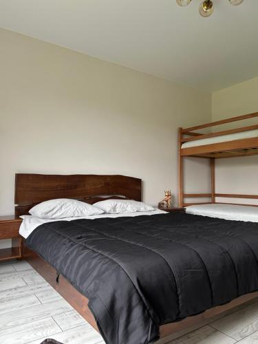 a bedroom with a large bed with a black blanket at Villa Bory in Vygoda