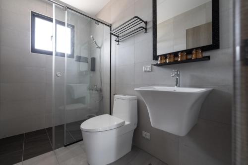 a bathroom with a toilet and a sink and a shower at IsShoNi B&B in Huxi