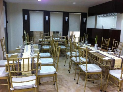a room with long tables and chairs with white seats at Metro Vigan Inn MAIN in San Vincente