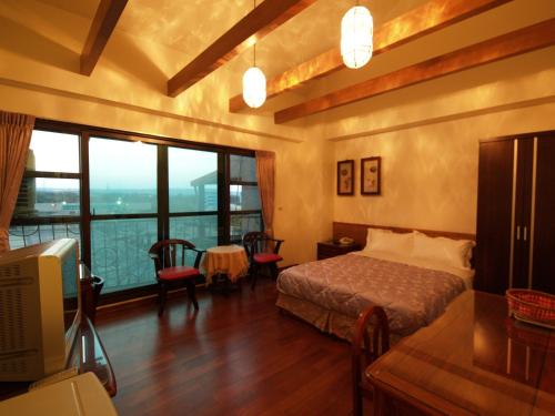 Un dormitorio con una cama y una mesa y sillas. en Nanwan Jiahewu Inn, en Nanwan