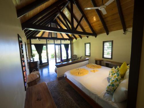 a bedroom with a large bed in a room with windows at Taveuni Dive Resort in Waiyevo