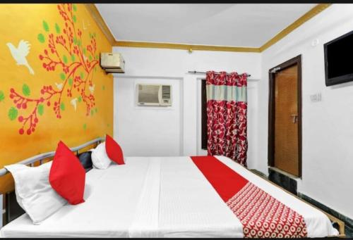 a bedroom with a large bed with red pillows at RROOMS Eco Hotel Best in Lucknow