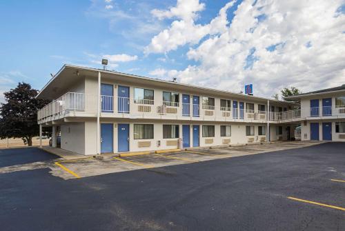 um grande edifício com janelas azuis e um parque de estacionamento em Motel 6-Rochester, MN em Rochester