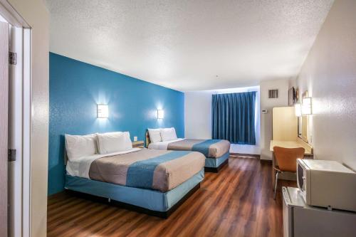 a hotel room with two beds and a blue wall at Motel 6 New Braunfels in New Braunfels