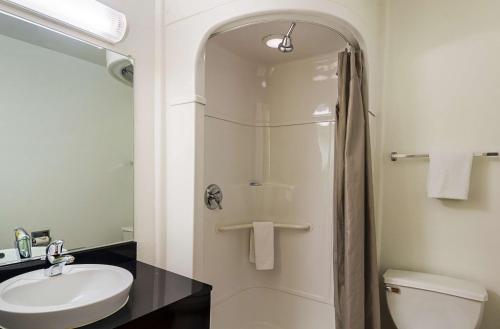 a bathroom with a shower and a sink and a toilet at Motel 6-Laramie, WY in Laramie