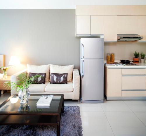 a living room with a couch and a refrigerator at Viva Garden Serviced Residence in Bangkok