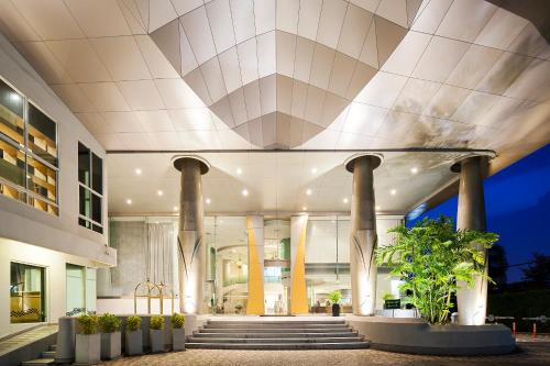 a lobby of a building with pillars and plants at Viva Garden Serviced Residence in Bangkok