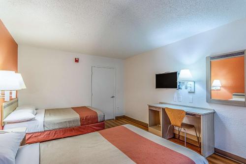 a hotel room with two beds and a desk at Motel 6 Modesto, CA in Modesto