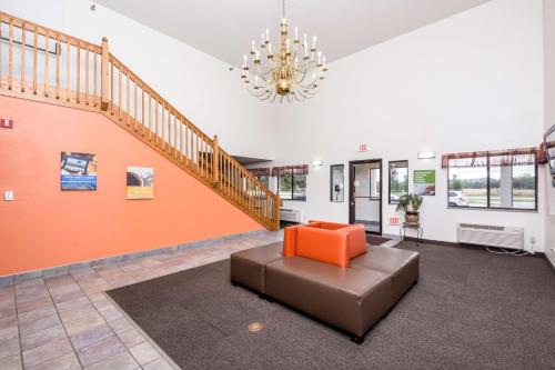 a living room with a couch and a staircase at Motel 6-Waterloo, IA in Waterloo