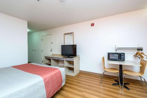 a hotel room with a bed and a desk with a computer at Motel 6-Waterloo, IA in Waterloo