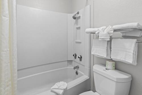 a bathroom with a tub and a toilet and towels at Americas Best Value Inn Austin in Austin