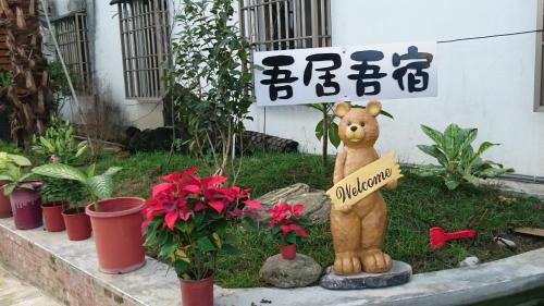a statue of a teddy bear holding a sign at 吾居吾宿 in Zhixue