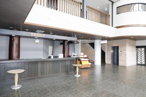 a lobby with a front counter and two stools at Fuji Yamanakako Hotel in Yamanakako