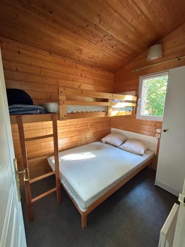 a bedroom with a bed in a wooden cabin at Camping L'Amandier in Gigors