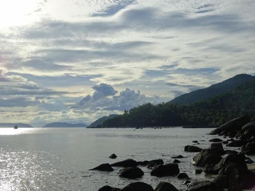 a large body of water with rocks on the shore at Cham Island Smiles Homestay in Tân Hiệp