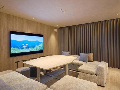 a conference room with a table and chairs and a tv at Rakuten STAY VILLA Yufuin Onsen in Yufu