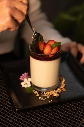a dessert on a black plate with a spoon at Mesón De Leyendas Breakfast & Downtown in Valle de Bravo