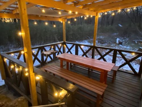 a wooden deck with a bench and lights on it at コテージオギー in Nasu