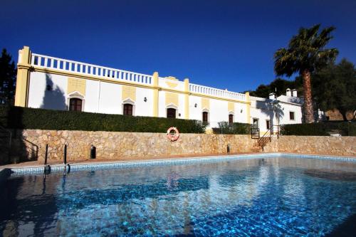 a large swimming pool in front of a building at Herdade Da Corte in Tavira