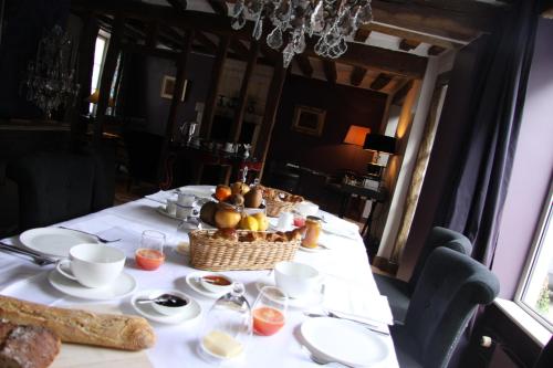 a table with a basket of fruit and bread on it at L'Hibernie in Rochefort-en-Yvelines