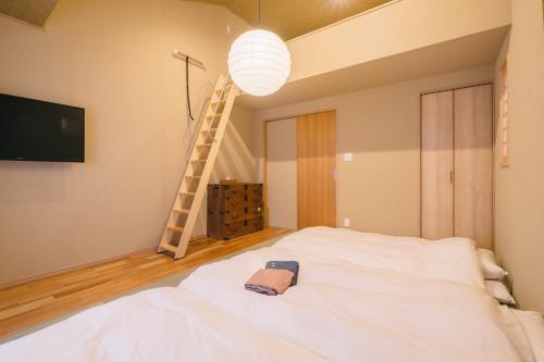 a bedroom with a white bed and a ladder at Miro Sanjo Saiin Tei in Kyoto