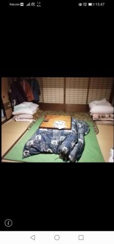 a bed with a comforter on top of it at z Authentic Trad Villa experience in Onomichi