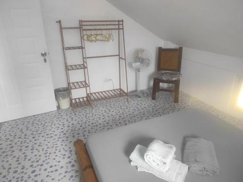 a bathroom with a tub and a fan and a clock at Koa's Beach House in Tangalan