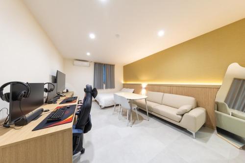 an office with a couch and a desk with a computer at Agabara Gangneung in Gangneung