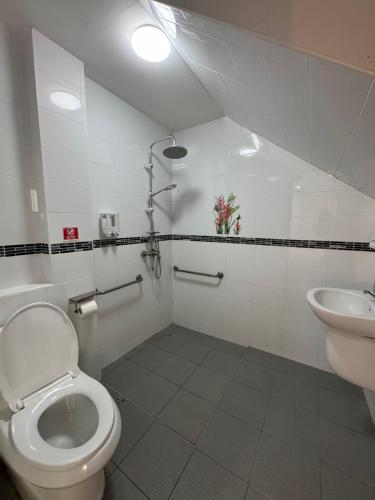 a bathroom with a toilet and a sink at Pathaya in Ban Kata